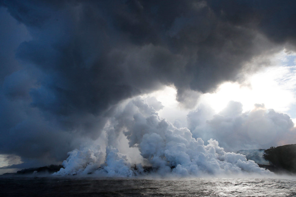 Plumes of steam rise as lava enters the ocean near Pahoa, Hawaii on May 20. (AP Photo/Jae C. Hong)
