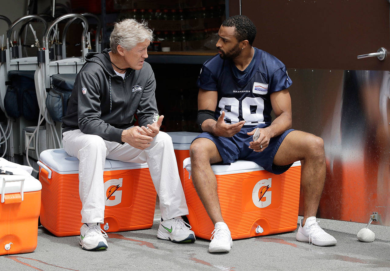Seahawks wide receiver Doug Baldwin (right) talks with head coach Pete Carroll following a practice on May 24, 2018, in Renton. (AP Photo/Ted S. Warren)