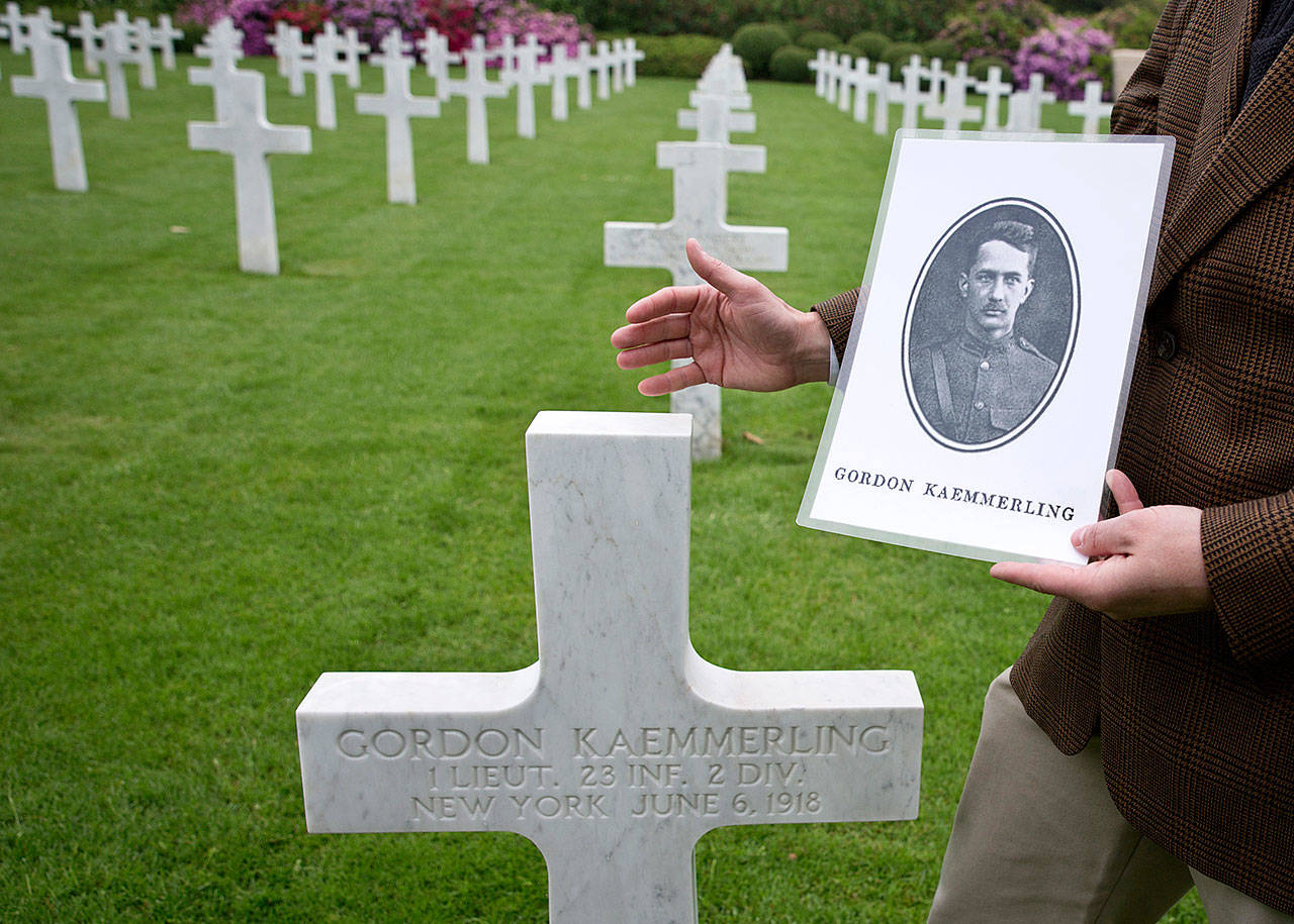 Superintendent of the Aisne Marne Cemetery, Shane Williams, holds a photo of World War I soldier Lt. Gordon Kaemmerling as he stands in front of his headstone at the World War I Aisne Marne cemetery in Belleau, France on Wednesday. The World War I battle of Belleau Wood in northern France pitted untested U.S. forces against the more-experienced Germans, who were making a push toward Paris. It became a defining moment, proving the Americans’ military mettle and helping turn the tide of the war. (AP Photo/Virginia Mayo)