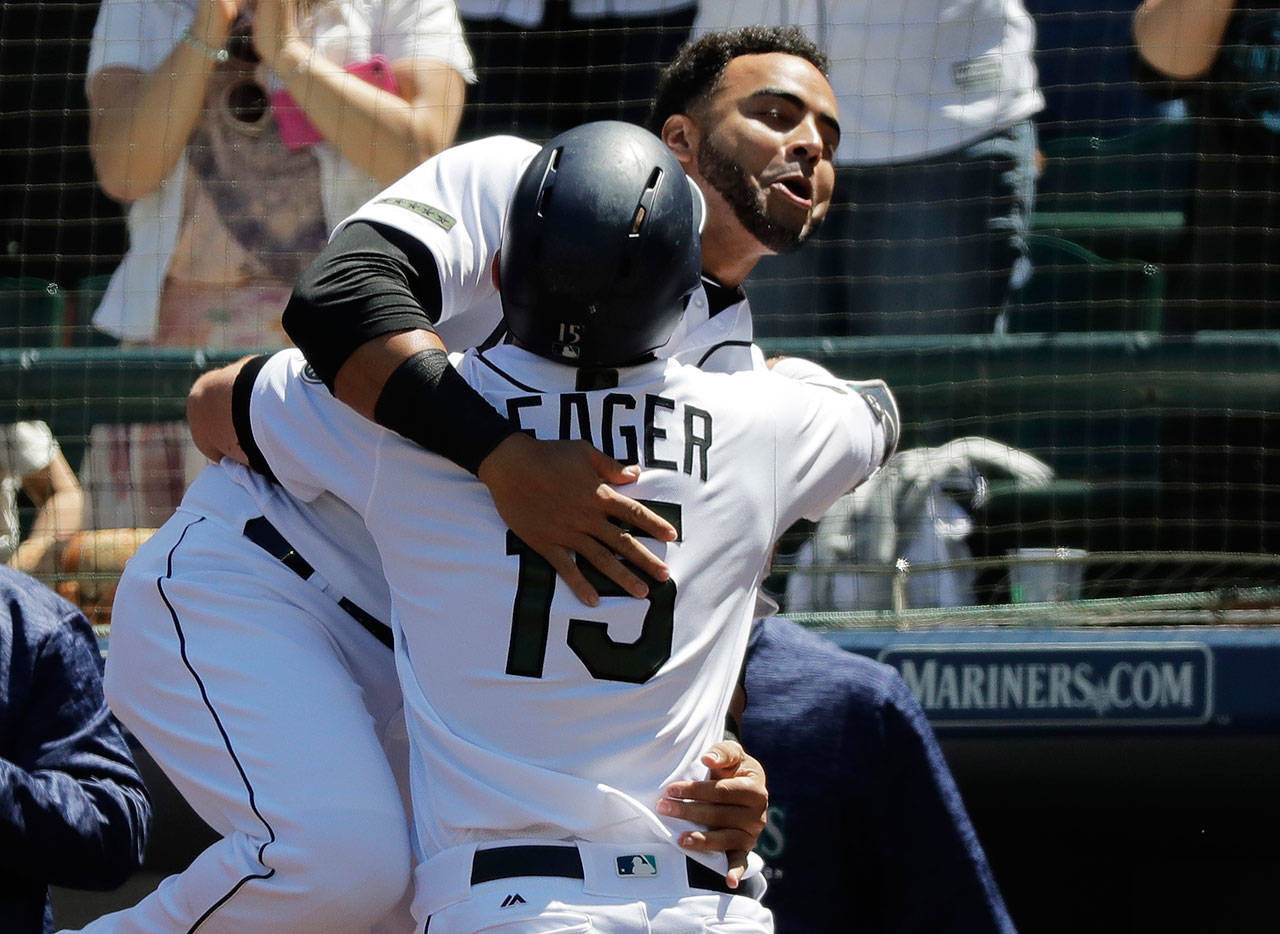 The Mariners’ Kyle Seager (15) is hugged by Nelson Cruz after Seager hit a solo home run against the Twins in the fourth inning of a game May 27, 2018, in Seattle. (AP Photo/Ted S. Warren)