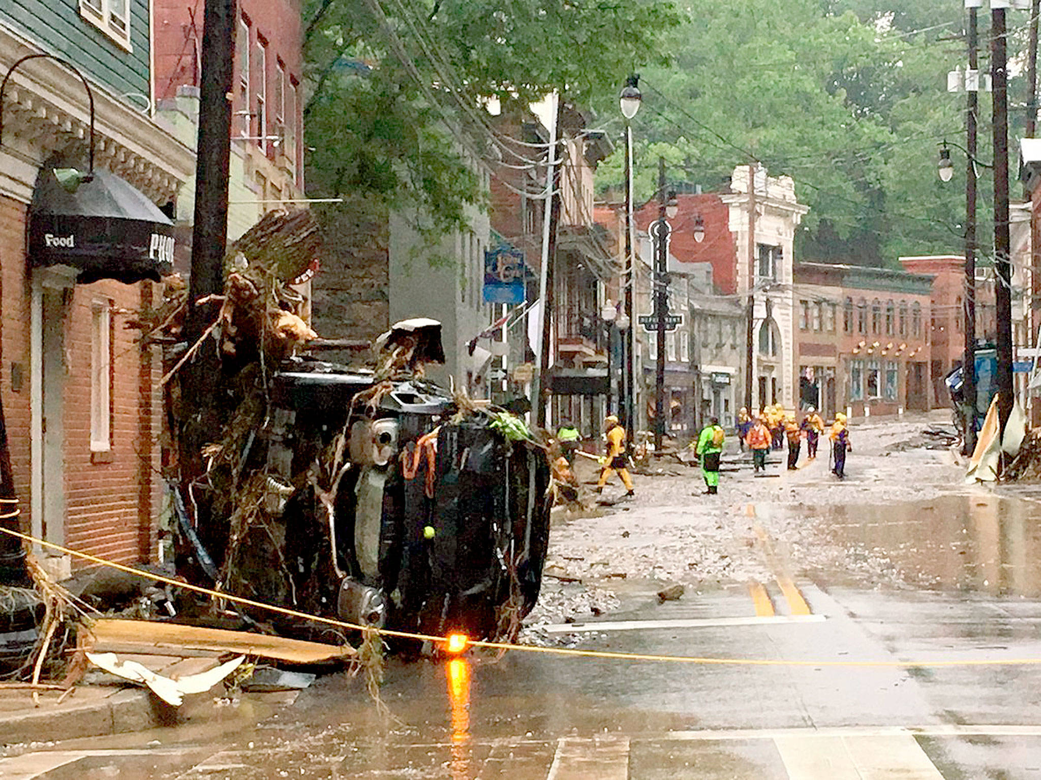 Rescue personnel walk along Main Street in Ellicott City, Maryland, on Sunday after a roaring flash flood swept away parked cars. (Libby Solomon/The Baltimore Sun via AP)