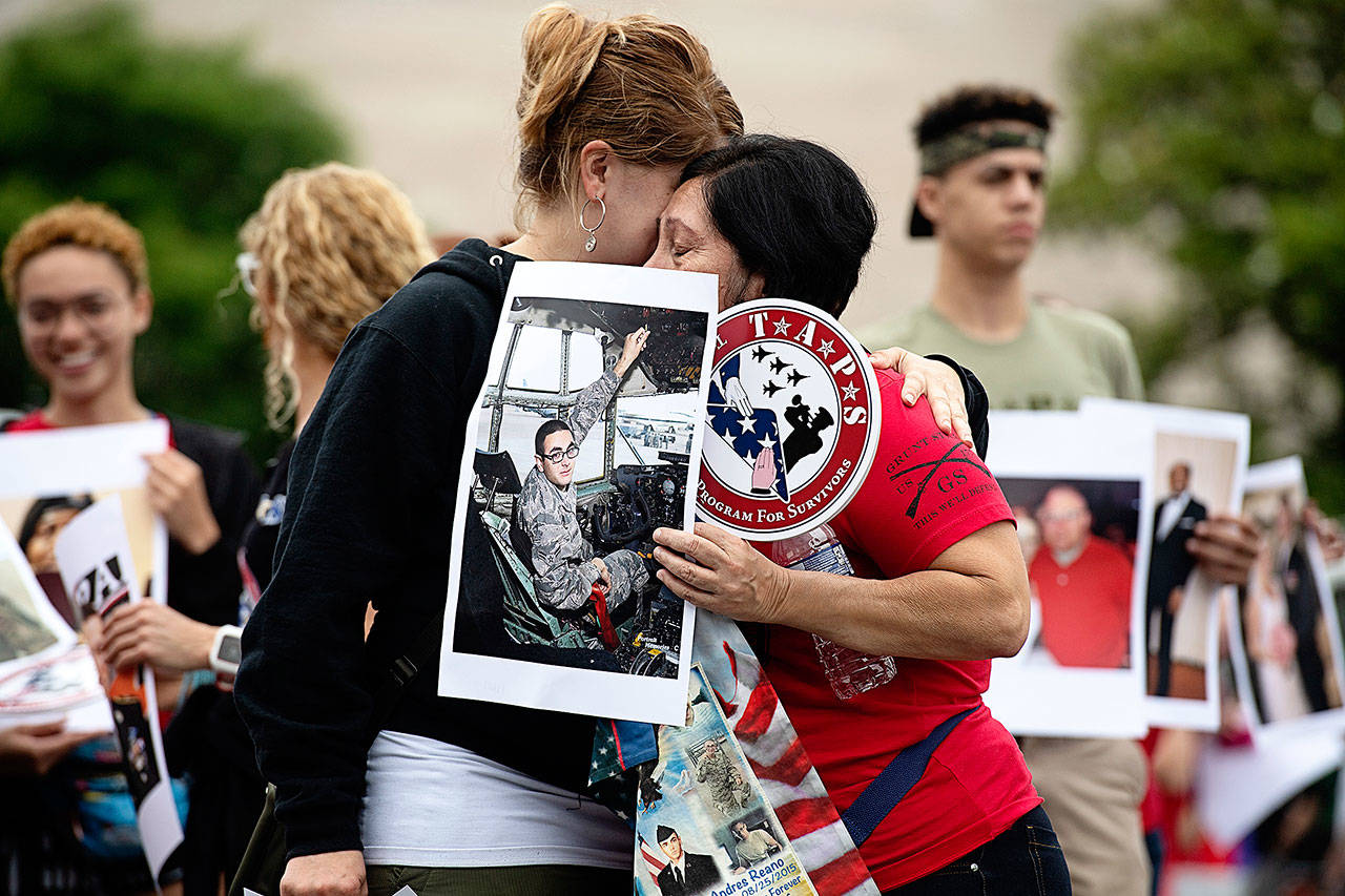 Emily Munoz (left) and Samira Chagua embrace as they march with others who have lost a loved one to war. They are members of a group named TAPS and were photographed in Washington, D.C., on Monday. Washington Post photo by Marvin Joseph