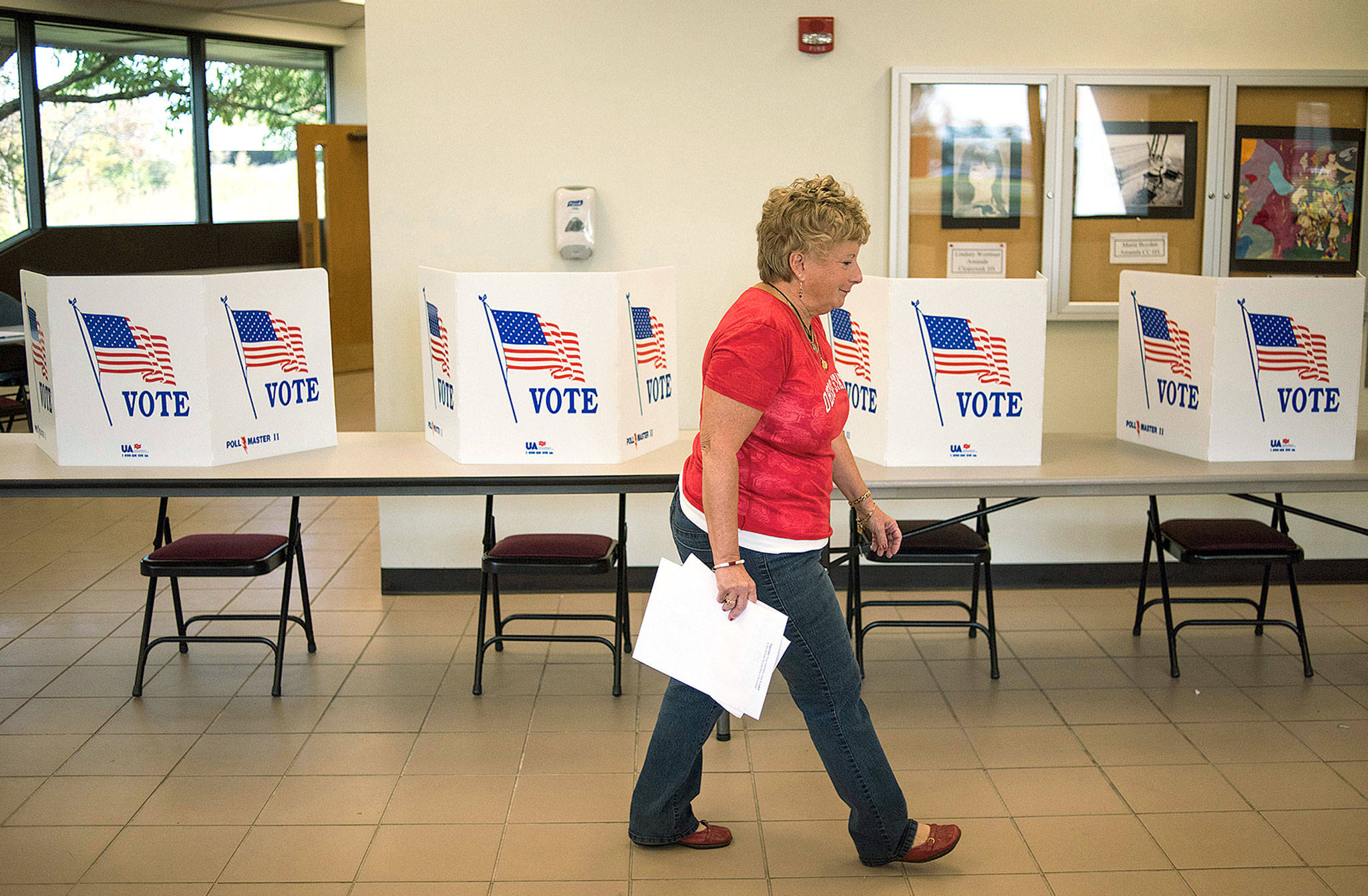 A polling official walks past voting booths at the Fairfield County Board of Elections Office in Lancaster, Ohio, in 2016. (Ty Wright / Bloomberg News)