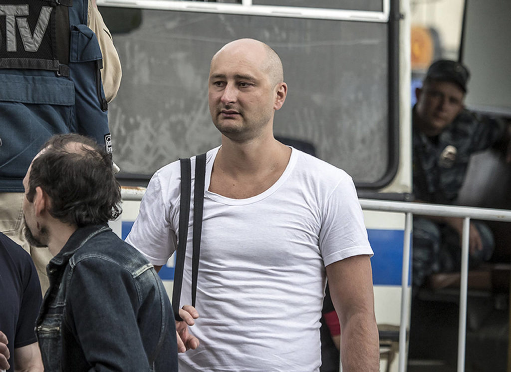 In this 2013 photo, Arkady Babchenko, 41, who had been scathingly critical of the Kremlin in recent years, stands at a police bus during an opposition rally in Moscow, Russia. (AP Photo/Alexander Baroshin)
