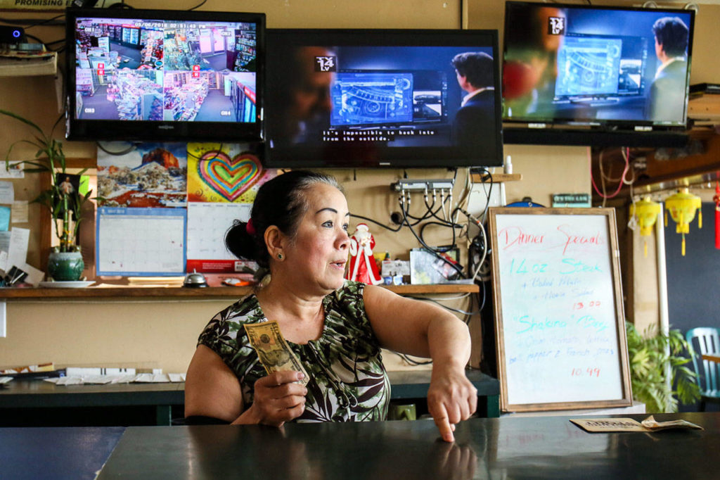 Oanh Nguyen, the market’s former owner for 17 years, works the counter at Riverview Market & Cafe. She continues to play a big role in the daily operation of the market and knows all the customers. (Kevin Clark / The Herald)

