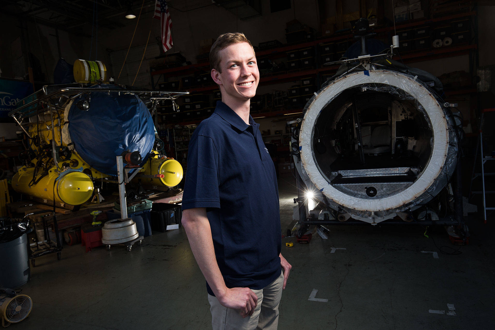 Josh Johnson, an intern for OceanGate, stands between two of the company’s submersibles on Wednesday, May 23, 2018 in Everett, Wa. Johnson, who graduates from ORCA this spring, has been tasked with constructing a 3D printer for the company.(Andy Bronson / The Herald)