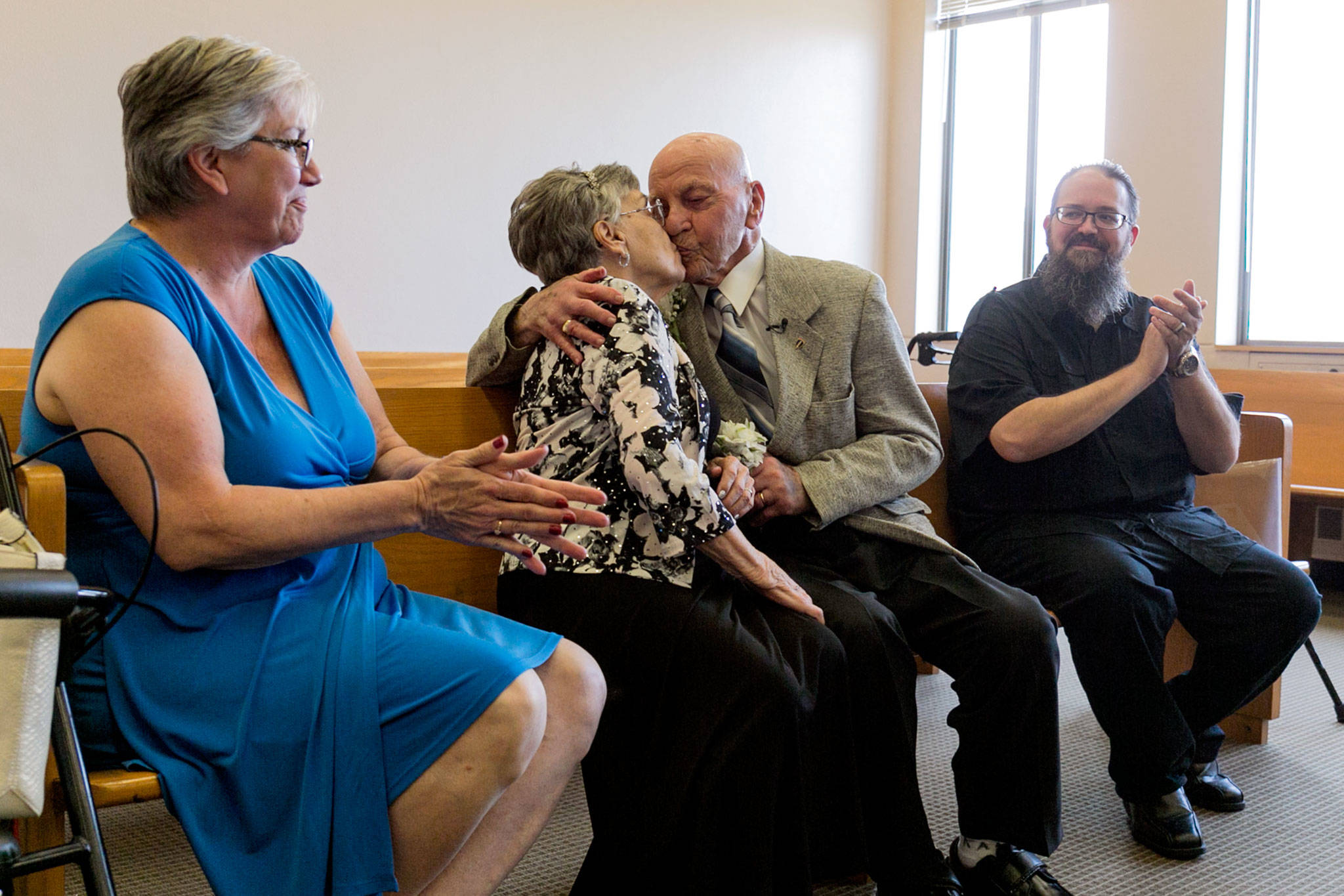 Marilyn Ogden and Kal Leichtman kiss to seal their wedding ceremony with her daughter, Patti Fredley, and his best man, William Brown, on Wednesday at the Snohomish County Courthouse in Everett. (Kevin Clark / The Herald)