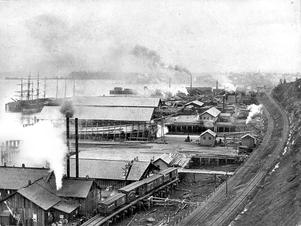 A bayfront scene appears to be a view looking north, near the mouth of the Snohomish River and what is now Legion Park.
