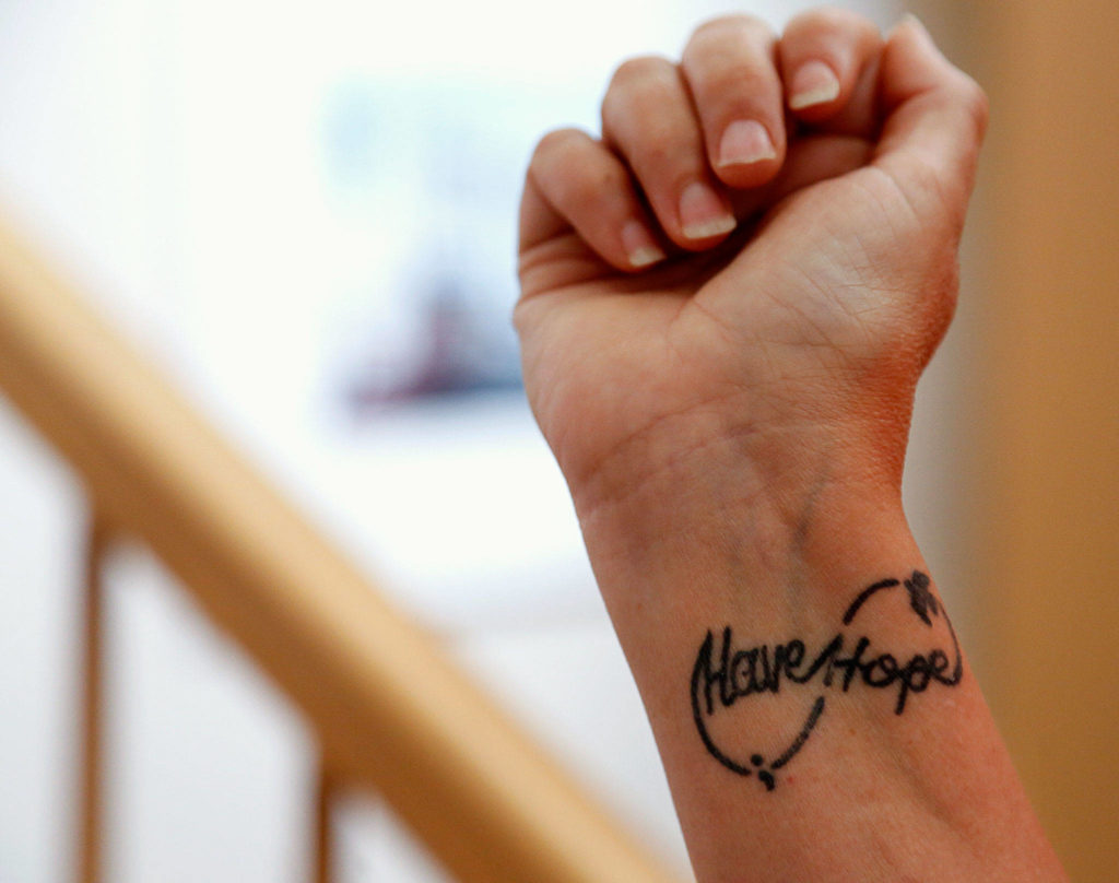 Judy Schneider-Wallace got her Have Hope tattoo while she and her children dealt with the loss of her first husband, who killed himself with a gun purchased just for that purpose. (Dan Bates / The Herald)
