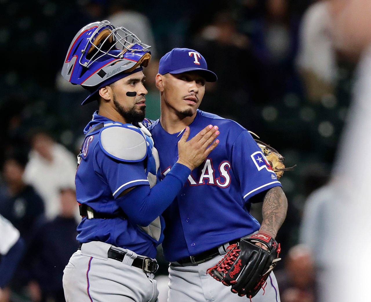 Texas Rangers closing pitcher Keone Kela, right, shares congratulations with catcher Robinson Chirinos after the Rangers defeated the Seattle Mariners 7-6 in a baseball game Wednesday, May 30, 2018, in Seattle. (AP Photo/Elaine Thompson)