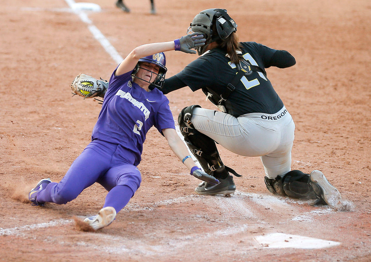 Washington’s Trysten Melhart (2), a Snohomish alum, slides home past Oregon’s Gwen Svekis (21) during a Women’s College World Series game on June 1, 2018, in Oklahoma City. Melhart scored on the play after Oregon was called for obstruction. (Bryan Terry / The Oklahoman via AP)