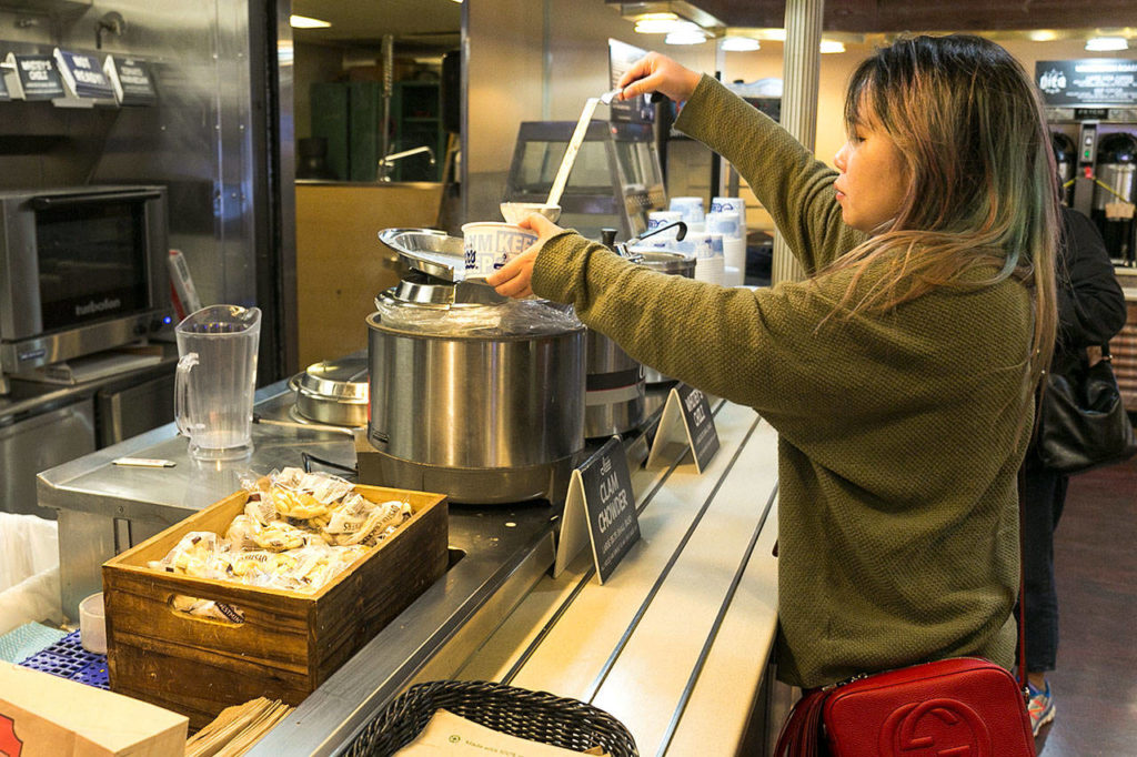 Suzie Zhu serves herself Ivar’s clam chowder on the Edmonds-Kingston ferry run. The floating food courts offer a variety of Washington products, including sandwiches, beer, wine and ice cream. Ivar’s soups are $4.50 to $5.75. (Kevin Clark / The Herald)
