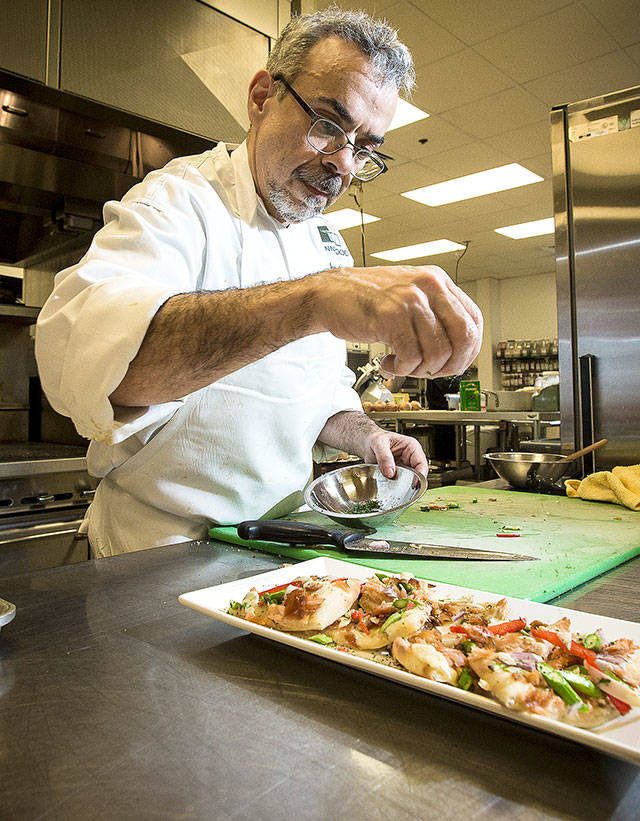 The Lynnwood Convention Center’s Michael Felsenstein puts the finishing touches on a smoked salmon and asparagus flatbread. (Ian Terry / The Herald)