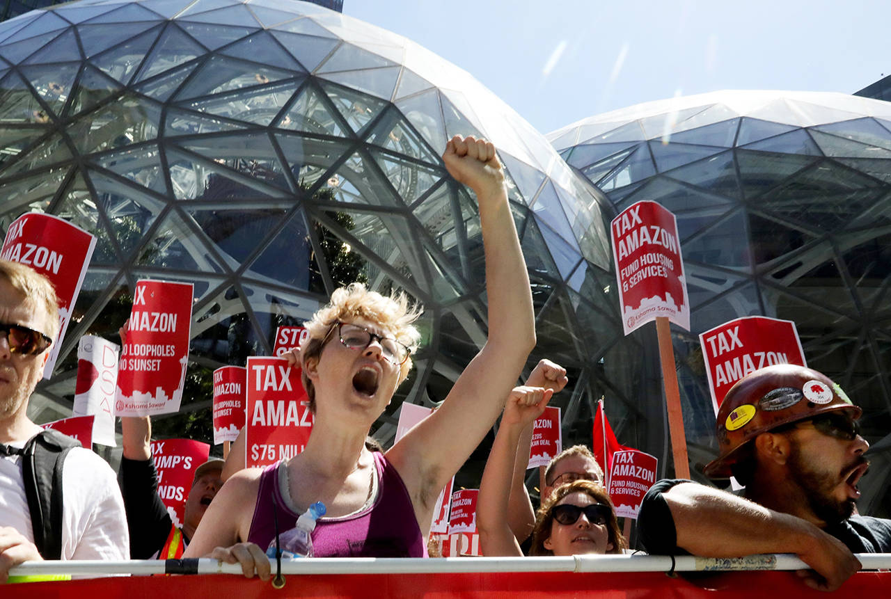 Kailyn Nicholson (center), with Socialist Alternative, continues anti-Amazon chants in front of the Spheres on Amazon’s campus on May 12. A different group has been collecting signatures for a referendum on the new tax. (Alan Berner/The Seattle Times via AP, file)