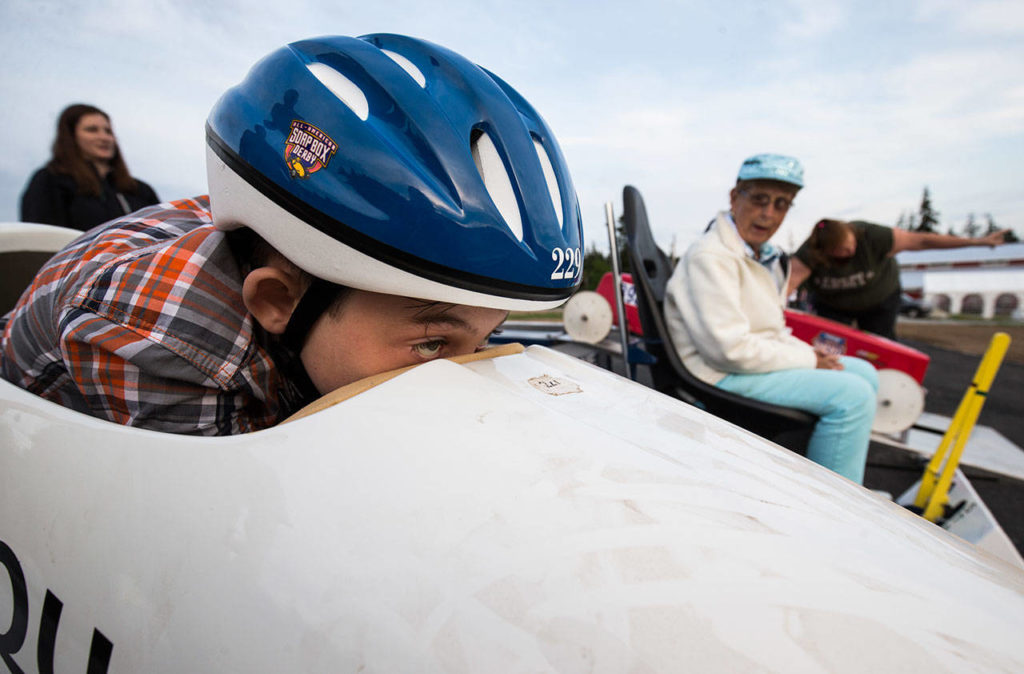 Micah Knowles, 10, gets ready for his first test ride in a practice soap box derby car on the track. (Andy Bronson / The Herald)
