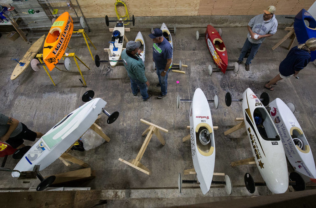 Parents and kids prep soap box derby cars outside the barn. (Andy Bronson / The Herald)
