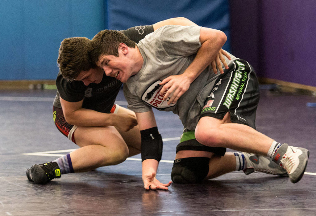 Team Washington member Cayden White, of Marysville Pilchuck, (right) tries to escape from teammate Riley Van Scoy, of Stanwood, during their practice Tuesday at Lake Stevens High School. (Andy Bronson / The Herald)
