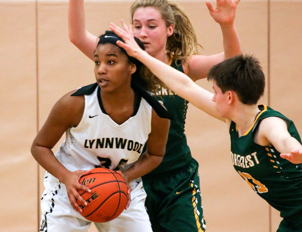 Lynnwood’s Kia Crawford (left) looks to pass against Shorecrest during a game on January 25, 2017, in Shoreline. (Kevin Clark / The Herald)
