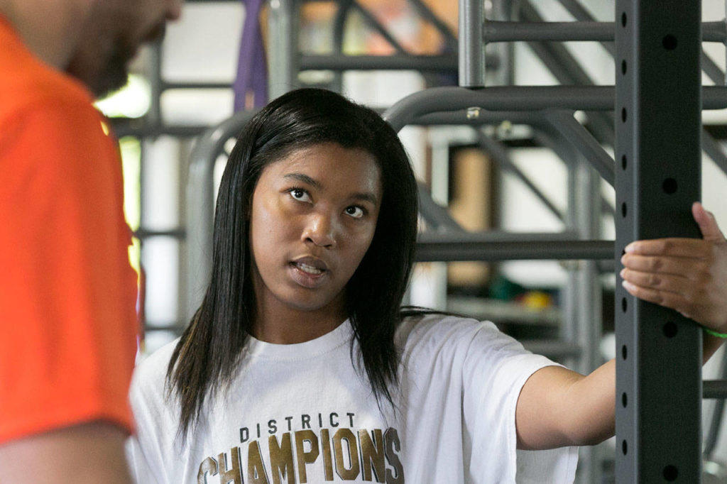 Kia Crawford (right) gets physical therapy instruction for Jared Appleby on May 9, 2018, at Experience Momentum in Lynnwood. (Kevin Clark / The Herald)
