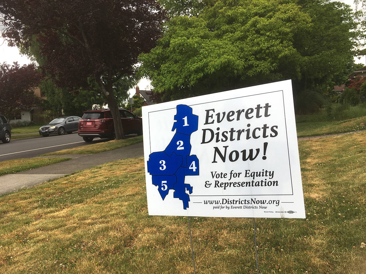 Some residents of Everett are showing their support for splitting the Everett City Council representation into geographic districts by displaying yard signs, such as this one seen on Rucker Ave. on Thursday. (Sue Misao / The Herald)