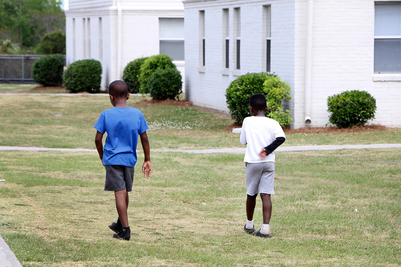 Two young boys walk across the grass of the Bridgeview Village Apartments in Charleston, South Carolina on May 14. (AP Photo/Robert Ray)