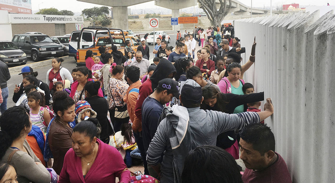 On Monday, people seeking political asylum in the United States line up to be interviewed in Tijuana, Mexico, just across the U.S. border south of San Diego. (AP Photo/Elliot Spagat)
