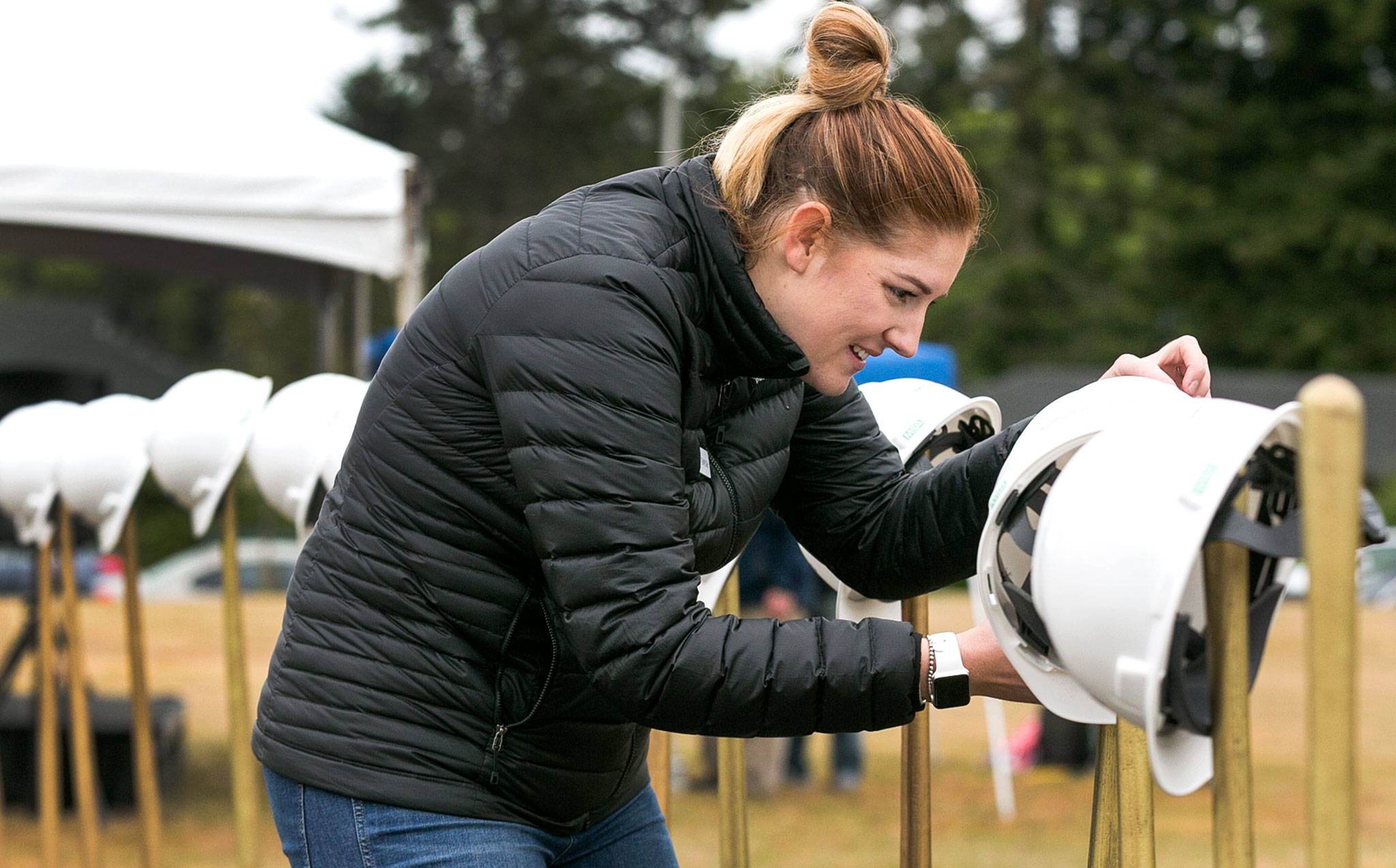 Shaylah Kugler hangs hard hats for the groundbreaking ceremony at the site of the new Everett Family YMCA Saturday morning. (Kevin Clark / The Herald)