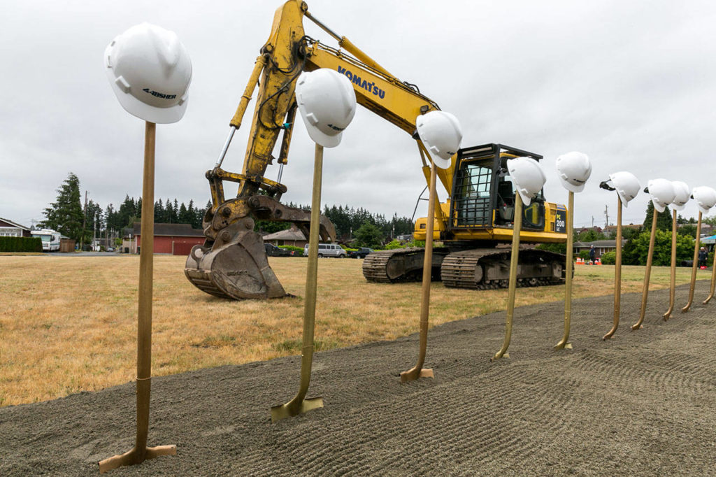 Hard hats, shovels and a backhoe decorate the site of the new Everett Family YMCA Saturday morning. (Kevin Clark / The Herald)
