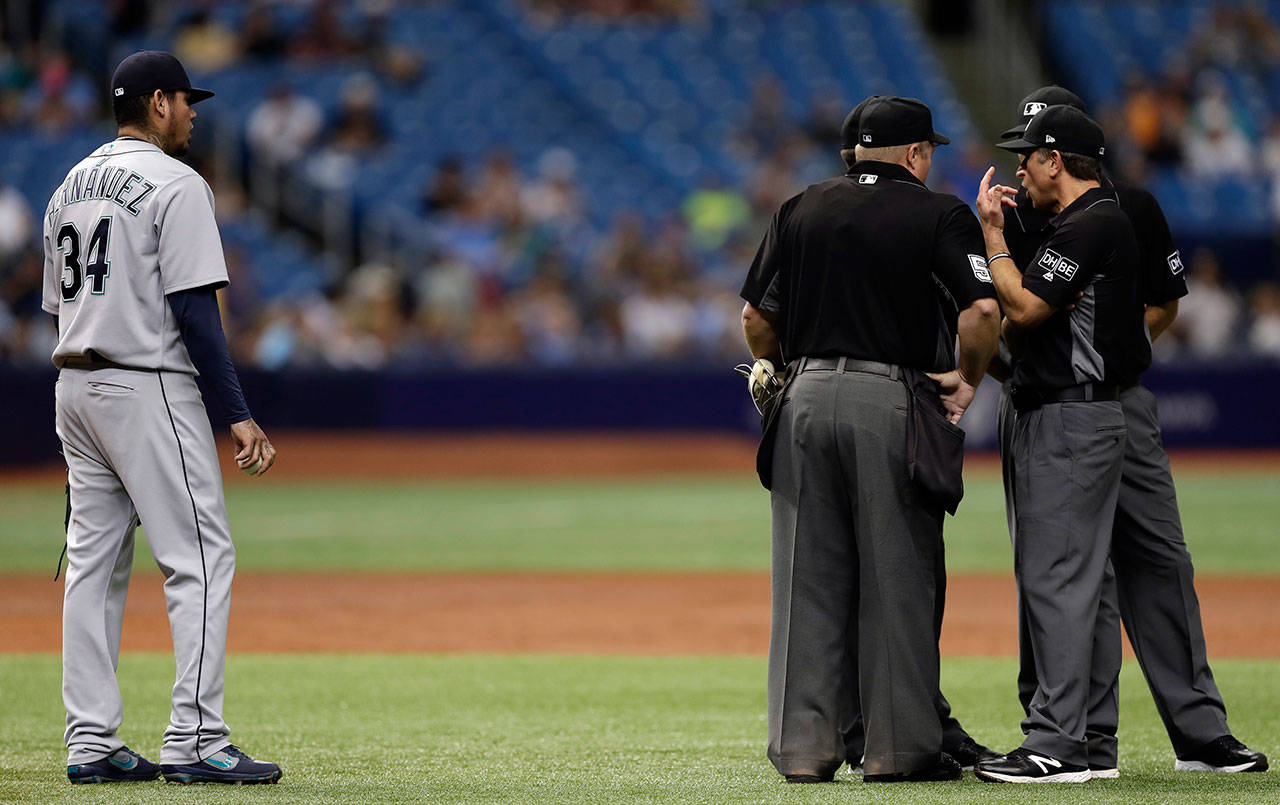 Seattle’s Felix Hernandez watches as umpires try and decide if Mallex Smith’s hit went over the fence during the third inning of Saturday’s game in St. Petersburg, Fla. After a review it was decided Smith tripled. (AP Photo/Chris O’Meara)