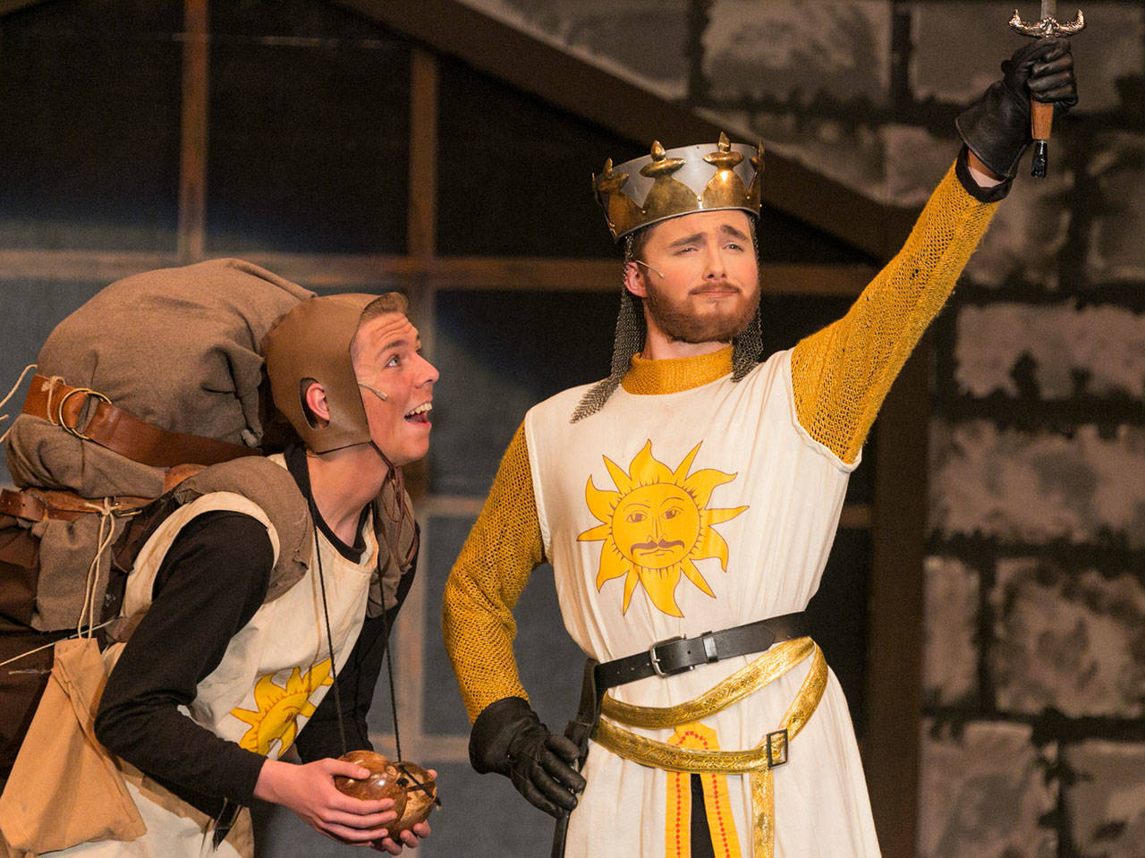 Kevin Clark / The Herald                                Gavin McKeever (left) as Patsy looks on a Aidan Norris as King Arthur raises Excalibur in “Spamalot.” Kamiak won two 5th Avenue Awards for its high school musical production.