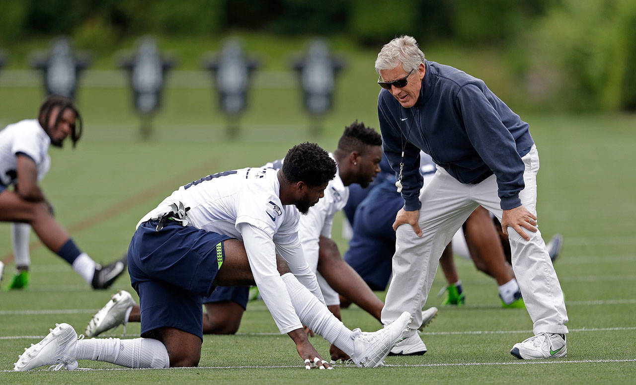 Seattle coach Pete Carroll greets Byron Maxwell during Tuesday’s practice session in Renton. (AP Photo/Elaine Thompson)