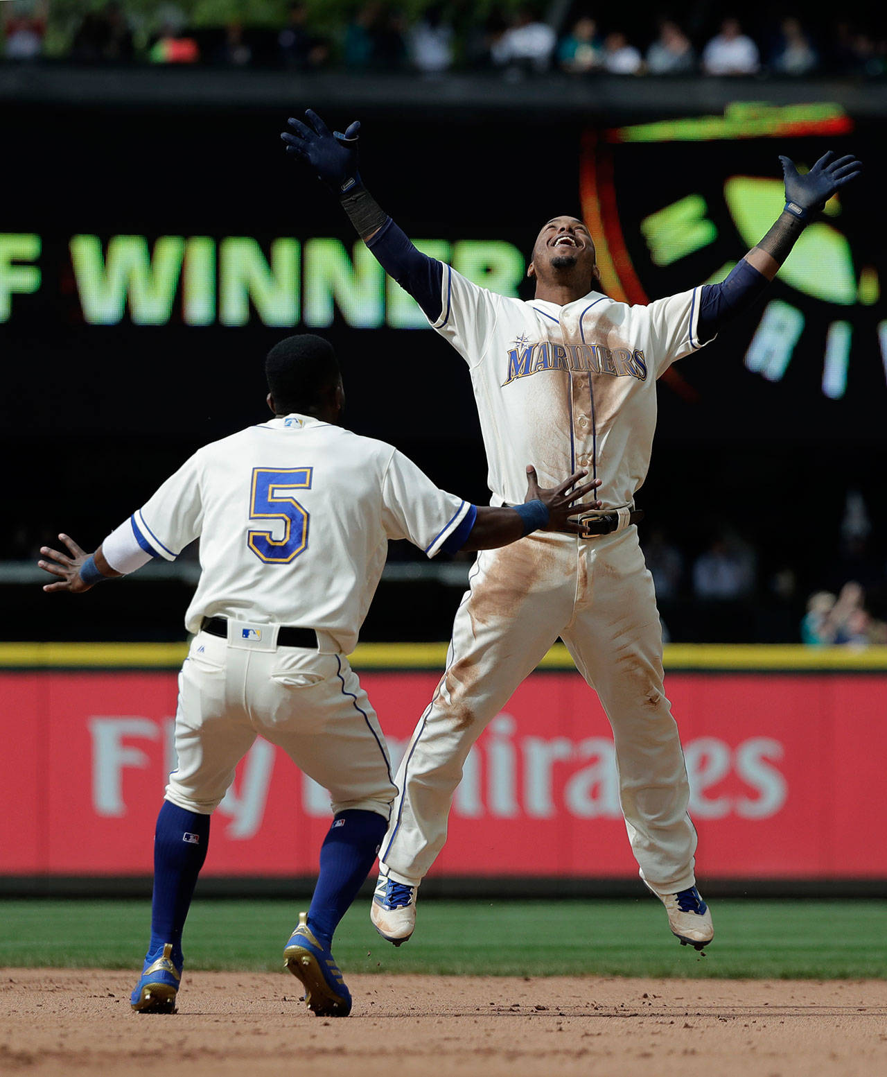 Seattle’s Jean Segura (right) celebrates with Guillermo Heredia after hitting a walkoff single in the 11th inning of a May 20 game at Safeco Field. (AP Photo/Ted S. Warren)