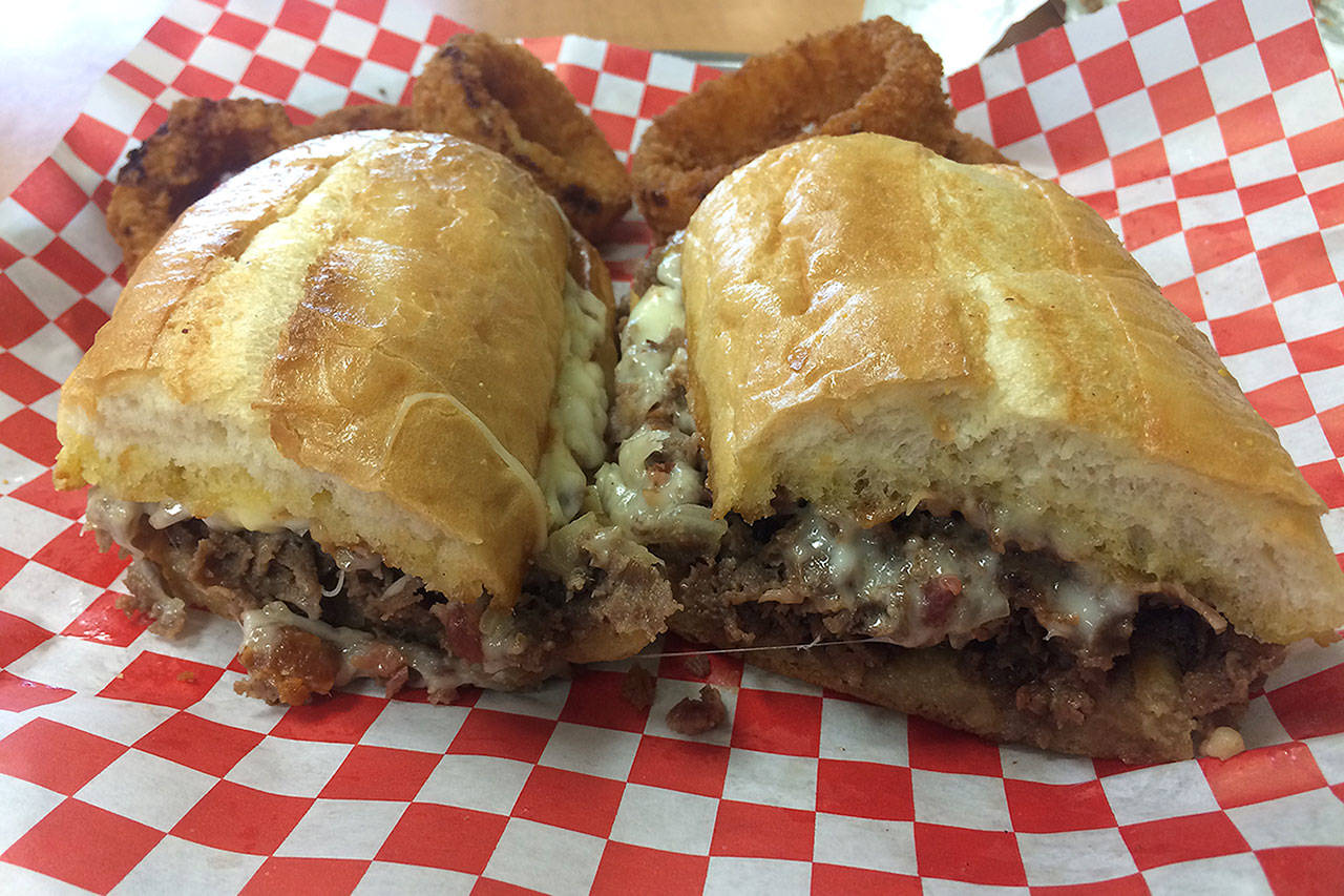 The bacon cheesesteak at Momi in Everett comes with provolone cheese, beefsteak slices, bacon crumbles and grilled onion. the traditional hoagie roll is toasted and slathered with butter and garlic mayonnaise. (Evan Thompson / The Herald)