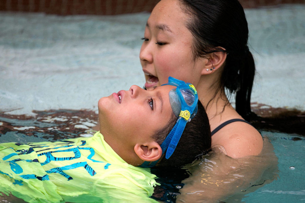 Alexis Song holds Marcus Reese during swim safety lessons Thursday afternoon at the Lynnwood Recreation Center. (Kevin Clark / The Herald)
