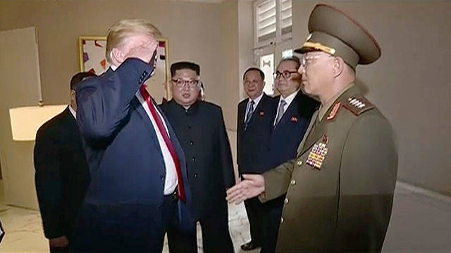 President Donald Trump salutes No Kwang Chol, minister of the People’s Armed Forces of North Korea, as North Korean leader Kim Jong Un (center), introduces Trump to the general during the summit in Singapore on Tuesday. (KRT)