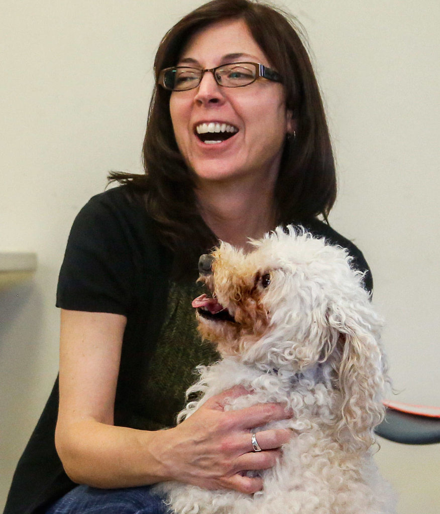 Glynis Frederiksen, manager of Everett Animal Services, enjoys a freindly hug with P.J.—formerly known as Poo Jr.— a poodle about 10 or 11 years old. P.J. was adopted Tuesday. (Dan Bates / The Herald)
