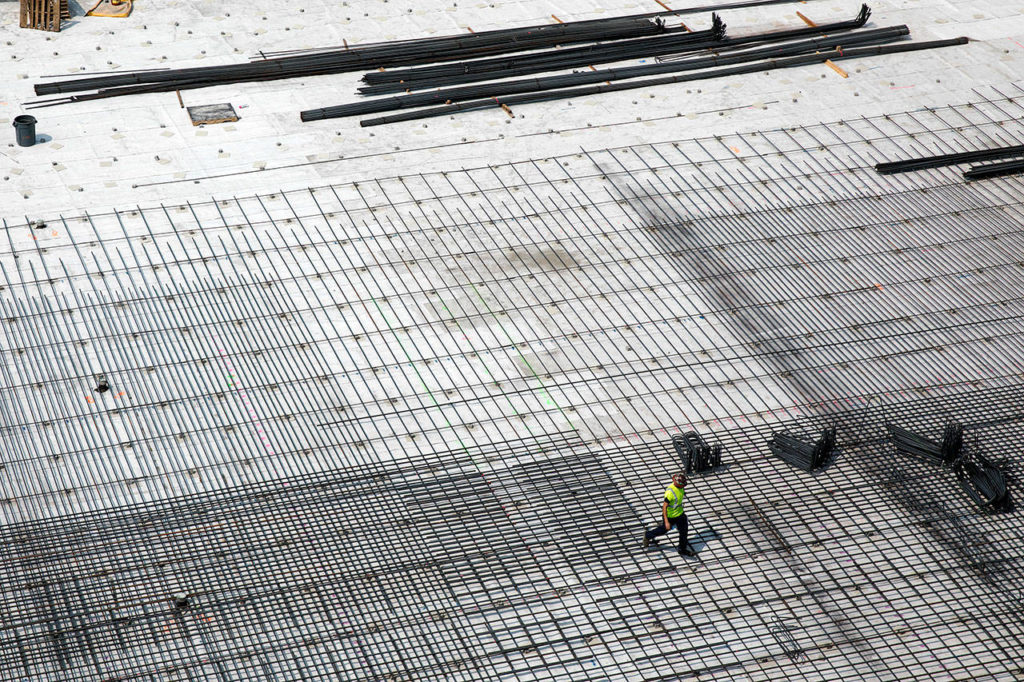A worker crosses over what will be the new parking garage for the Northgate Station in August 2017. (Lizz Giordano / The Herald)
