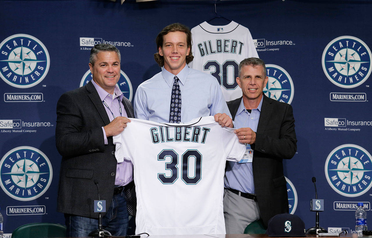 Seattle Mariners first-round draft pick Logan Gilbert is introduced at a news conference by director of amateur scouting Scott Hunter (left) and scout Rob Mummau on Saturday at Safeco Field. (AP Photo/John Froschauer)