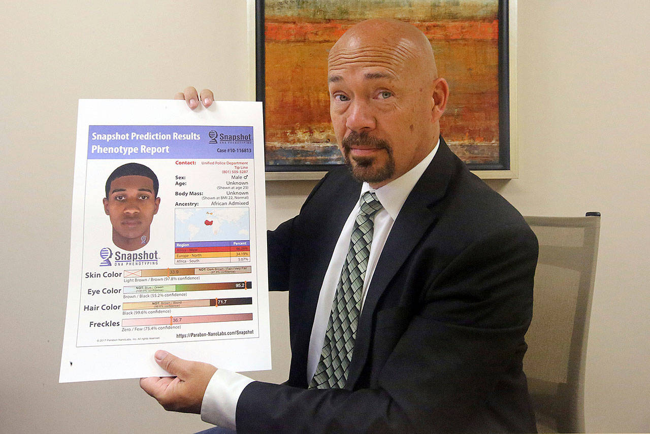 Private investigator Jason Jensen, of the Utah Cold Case Coalition, holds a DNA phenotype report at his office Friday in Salt Lake City. (AP Photo/Rick Bowmer)