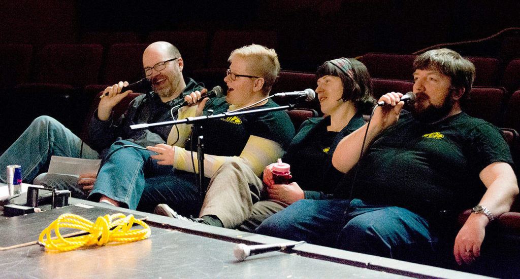 Jerry Haener, Lindsey Peterson, Amanda Marie Sproule and Glenn Bristol joke during a Twisted Flicks performance. The Jet City Improv members create dialogue, sound effects and music on the fly as a movie silently plays for an audience. (Duncan MacDonald / Jet City Improv)
