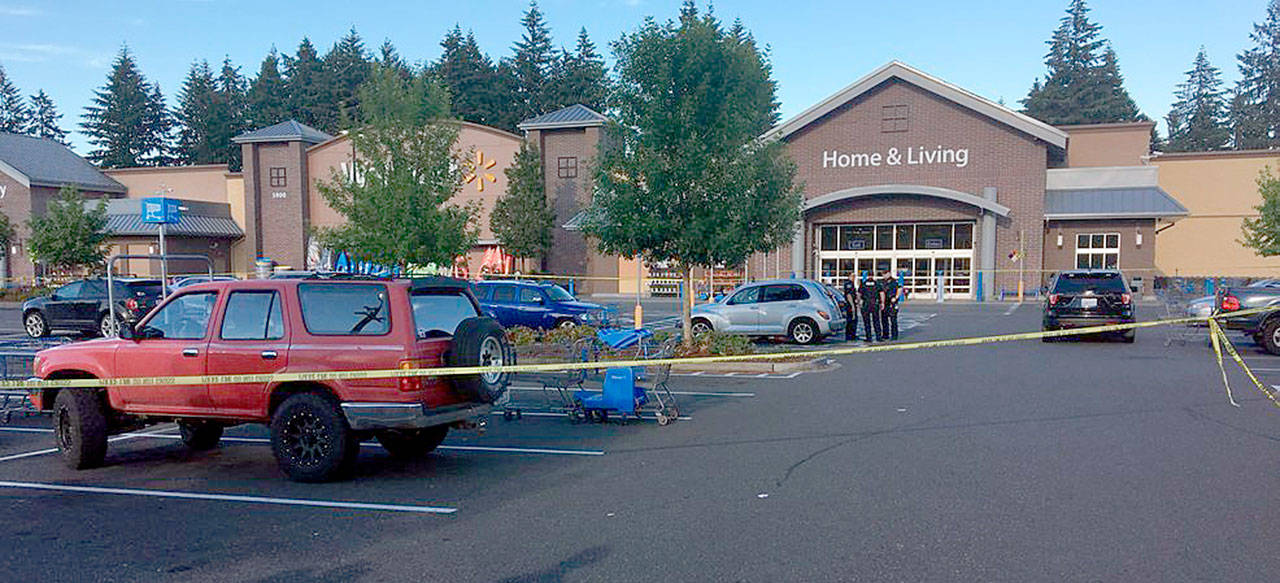 Police investigate the scene of a deadly shooting at a Walmart store in Tumwater on Sunday. (KOMO News via AP)