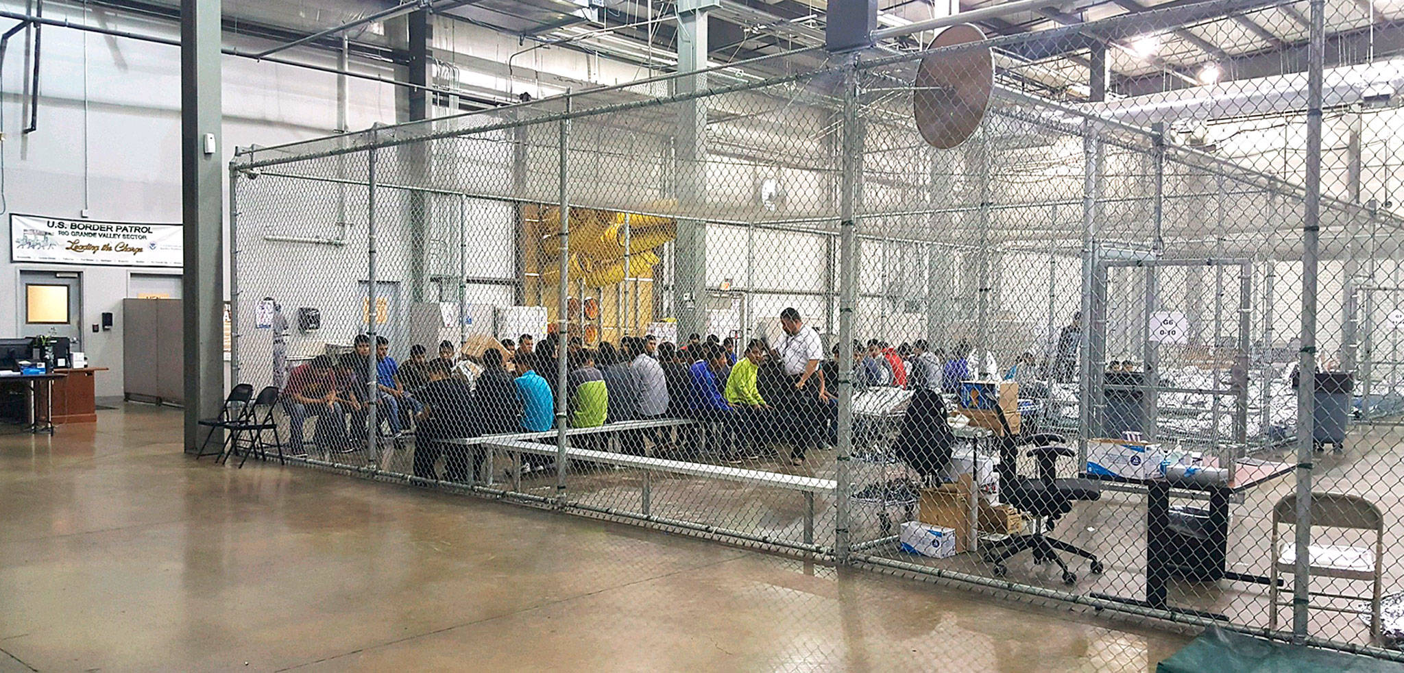 People who have been taken into custody in cases of illegal entry into the United States sit in a cage at a facility in McAllen, Texas, on Sunday. (U.S. Customs and Border Protection’s Rio Grande Valley Sector via AP)
