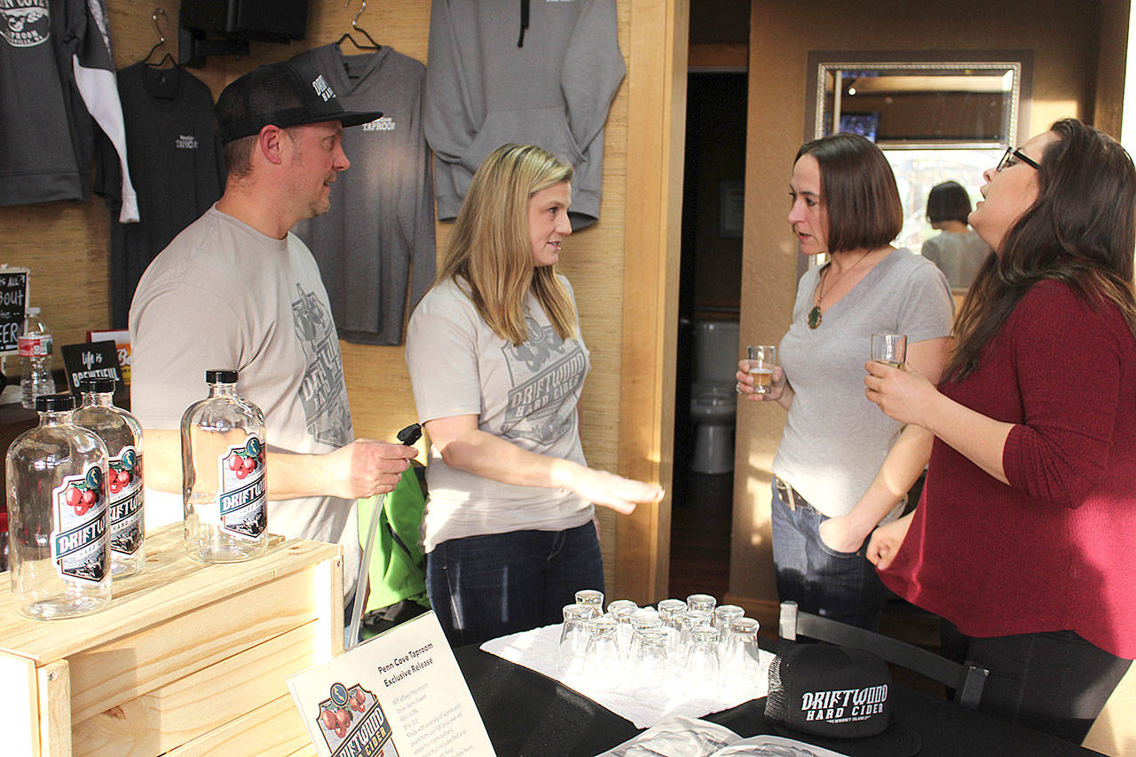 Jake and Lindsay Krug talk to customers trying out their Driftwood Hard Cider during a recent tasting. It’s currently on tap at three Whidbey bars and restaurants. (Patricia Guthrie/South Whidbey Record)