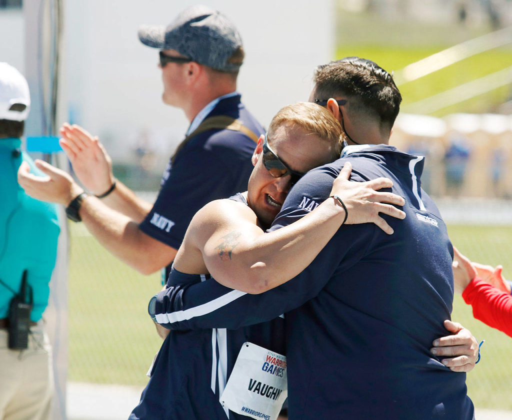 Navy Chief Petty Officer Tim Vaughn (left), of Marysville,	hugs track coach Kyle Putnam (right) after Vaughn competed in the men’s 1500 meters at the U.S. Air Force Academy near Colorado Springs, Colorado, on	June 2 . Vaughn is an athlete competing in the ninth edition of the Department of Defense Warrior Games. (Photo/Zoe L. Smith, Grady Sports Bureau)
