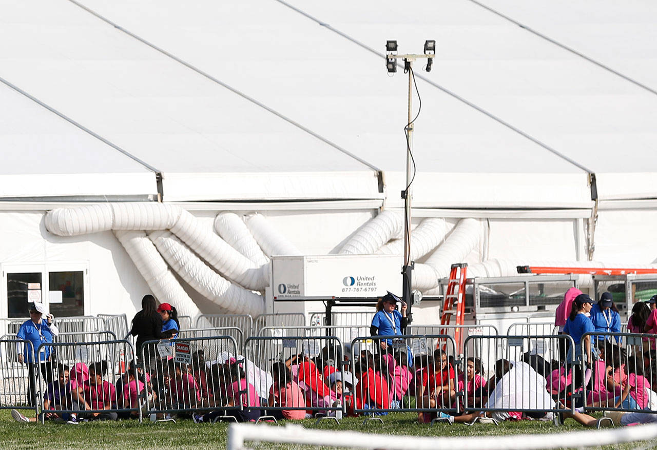 Immigrant children are shown outside a former Job Corps site that now houses them, Monday, in Homestead, Florida. It is not known if the children crossed the border as unaccompanied minors or were separated from family members. (AP Photo/Wilfredo Lee)