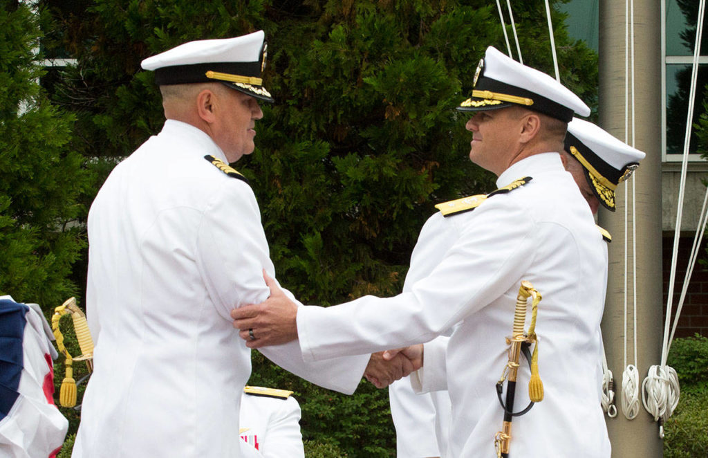 Capt. Mike Davis (right) shakes the hand of Capt. Mark Lakamp, relieving him as commanding officer of Naval Station Everett during the Change of Command Ceremony on Friday. (Andy Bronson / The Herald)
