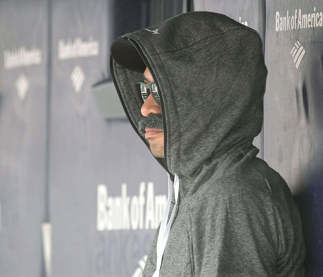 Ichiro Suzuki, special assistant to the chairman of the Seattle Mariners, wears a fake mustache and a hoodie in the dugout and watches the New York Yankees bat during the first inning of a baseball game Thursday at Yankee Stadium in New York. (AP Photo/Bill Kostroun)