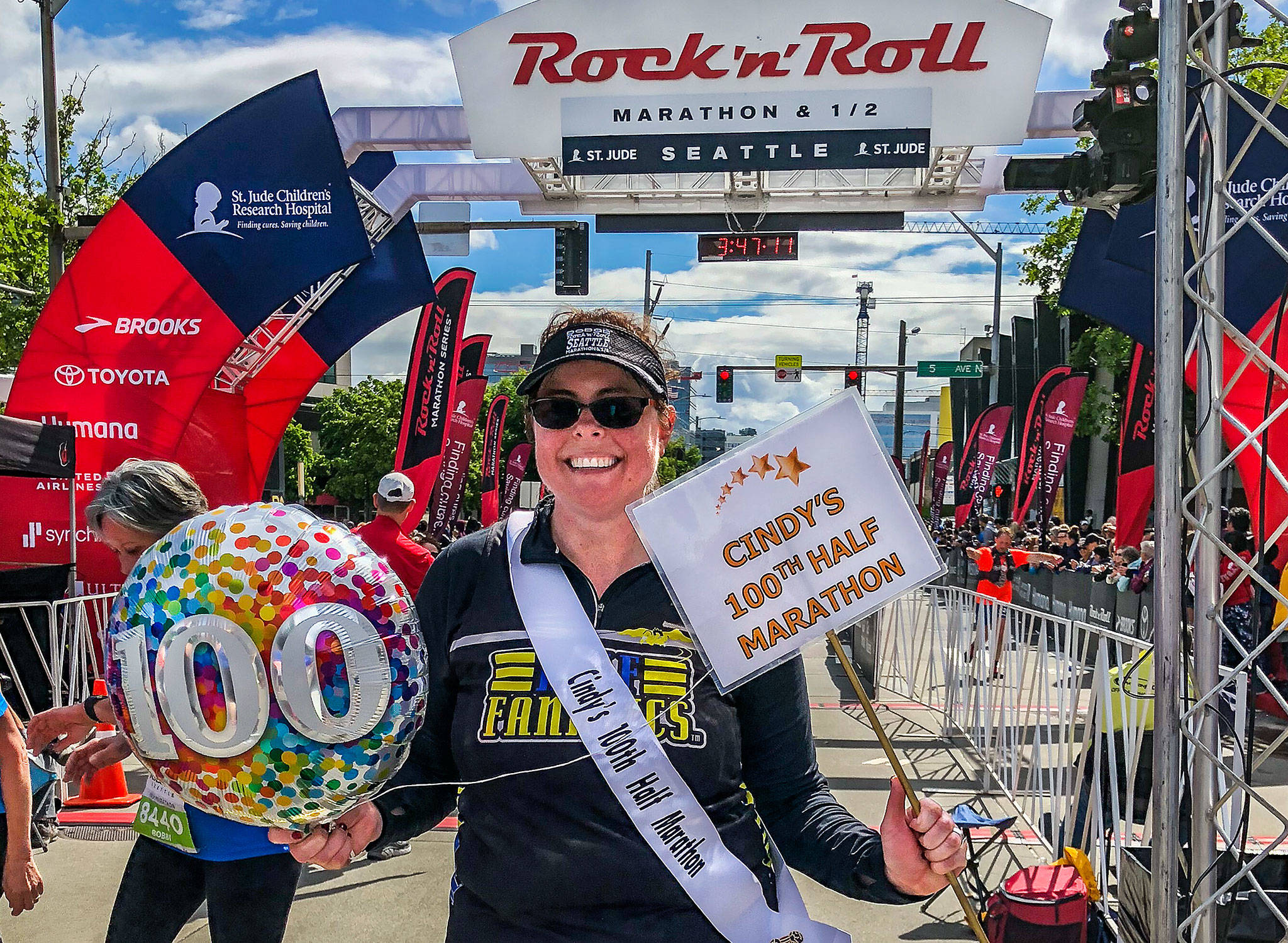 Lynnwood’s Cindy Ward, 42, completed her 100th half marathon earlier this month. Here, she celebrates at the finish line of the Rock ‘n’ Roll Seattle Half Marathon at Seattle Center. (Photo courtesy Cindy Ward and Gretchen Tapp)