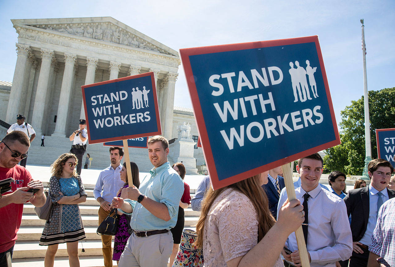 On Monday, people gathered at the Supreme Court awaiting a decision in an Illinois union dues case, Janus vs. AFSCME, in Washington. (AP Photo/J. Scott Applewhite)