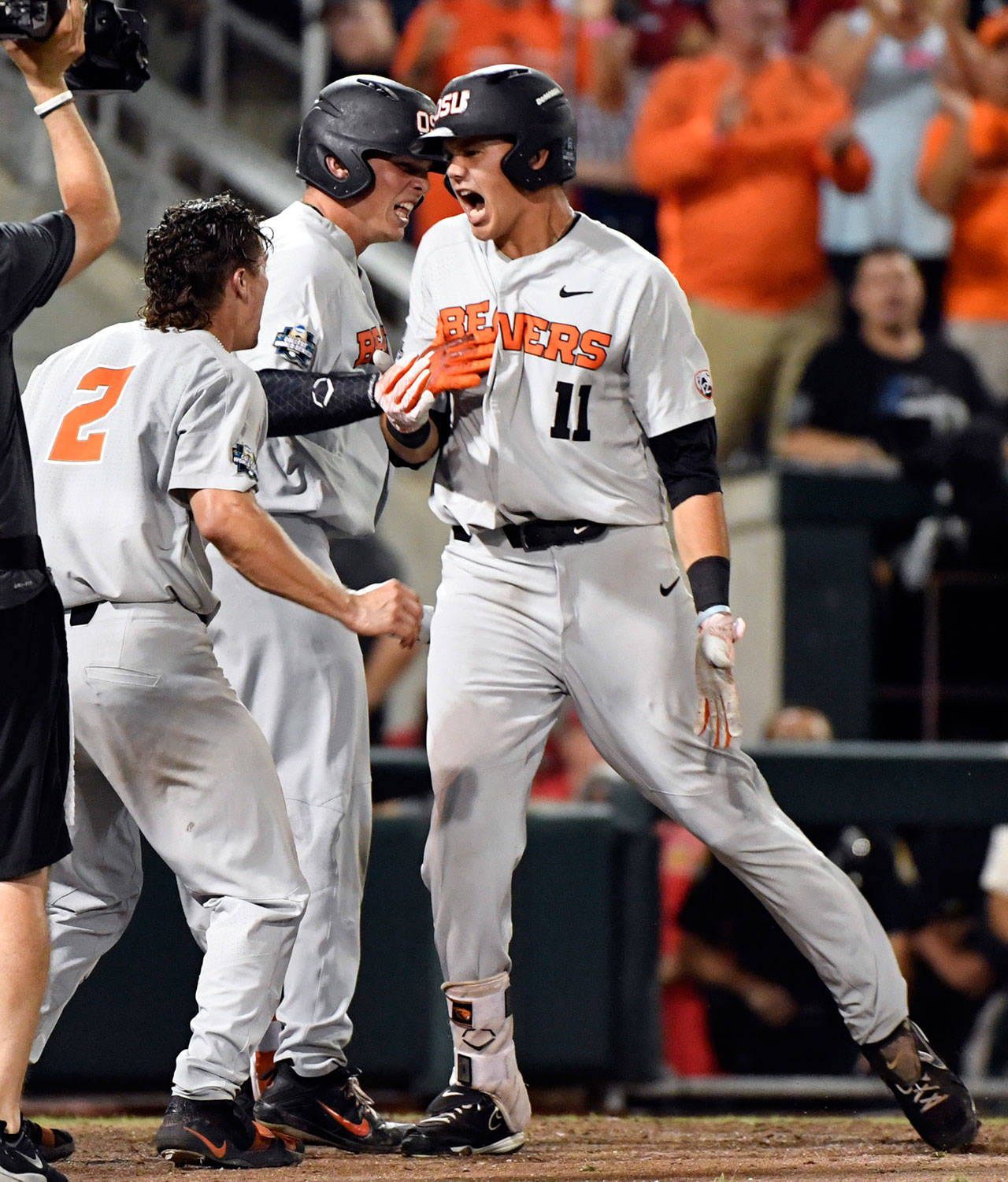 Oregon States Trevor Larnach (11 ) celebrates his two-run home run with Cadyn Grenier during the ninth inning of Wednesdays game in Omaha, Nebraska. (AP Photo/Ted Kirk)